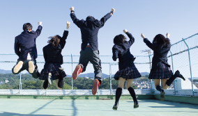 屋上でジャンプする高校生たちのイメージ